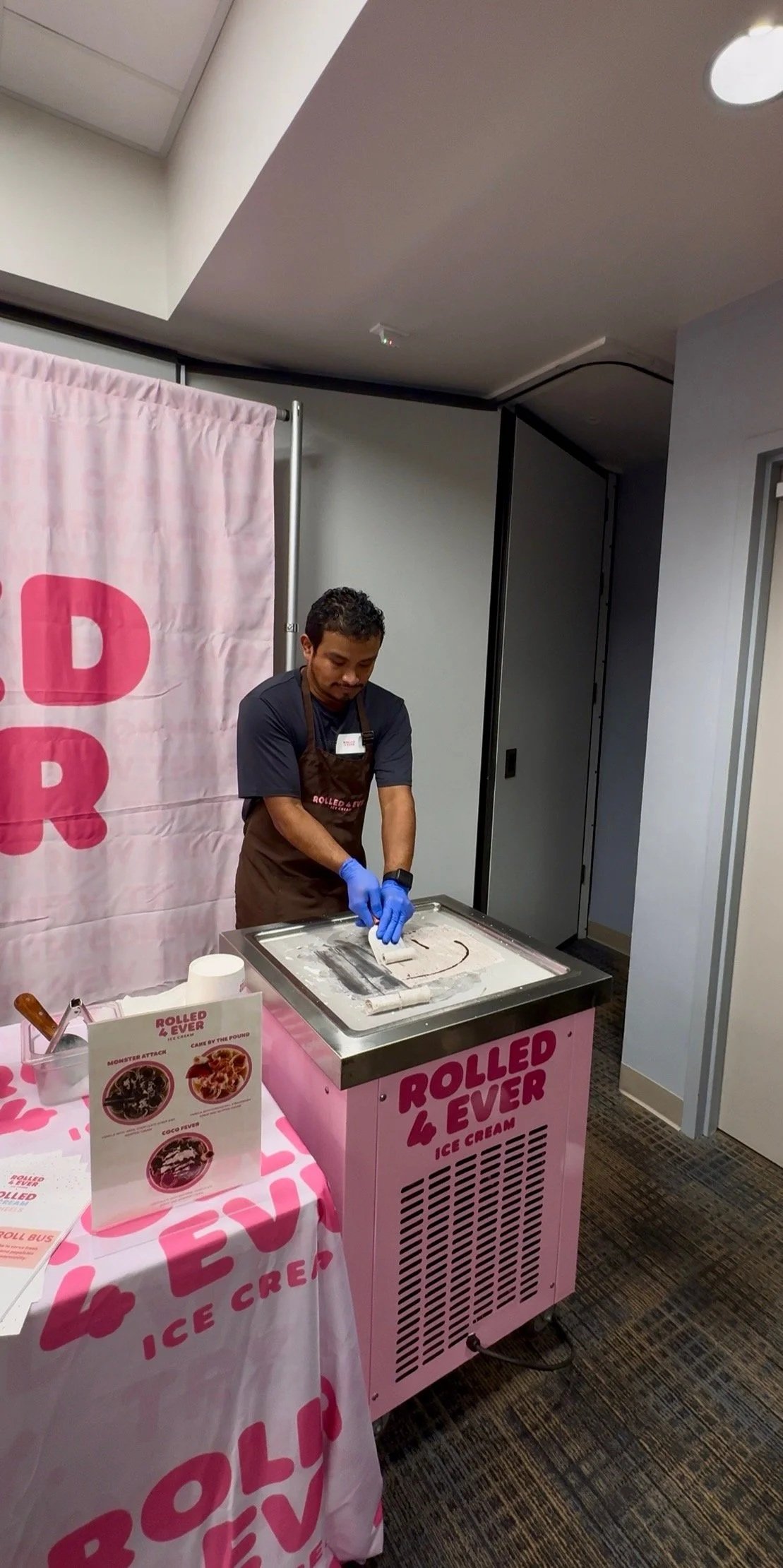 A Rolled 4 Ever team member rolling ice cream on the cold plate at an indoor event